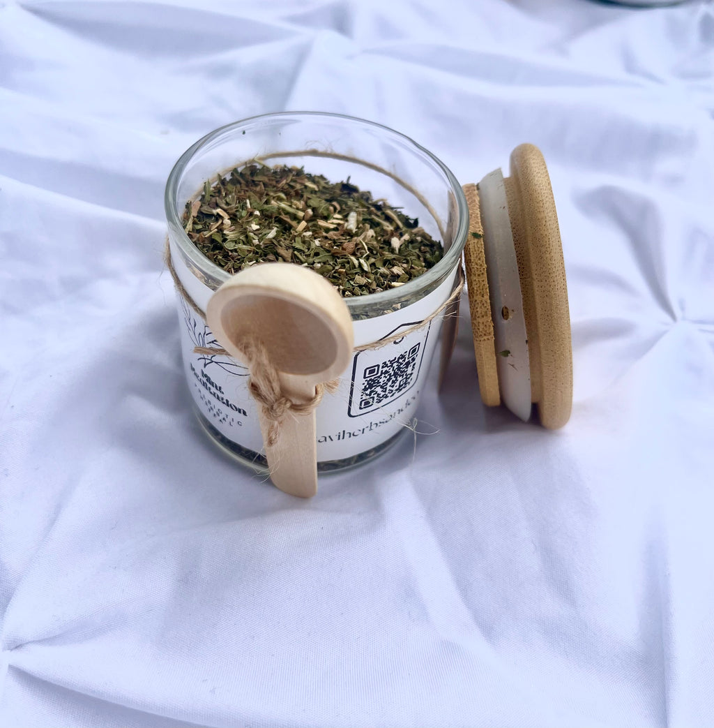 Glass jar with dried herbs on a white fabric background