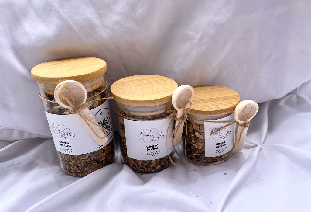 Three jars with wooden lids and labels on a white fabric background